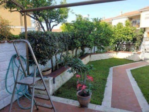 Faro da giardino con piante e siepi, spazio esterno ben curato con vialetto in pietra, ambiente tranquillo e verde.
