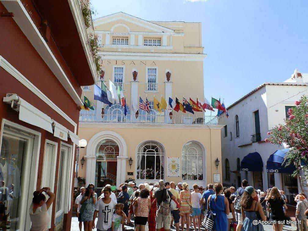 3 isole Flegree: Ischia, Procida e Capri tra mare, terme e borghi 13 Folla di turisti in Piazza a Capri, con edifici storici e bandiere italiane e straniere