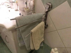 Asciugamani da bagno su portasciugamani in bagno, oltre a asciugamani colorati, in ambiente domestico, accanto a lavabo e prodotti per la cura personale.
