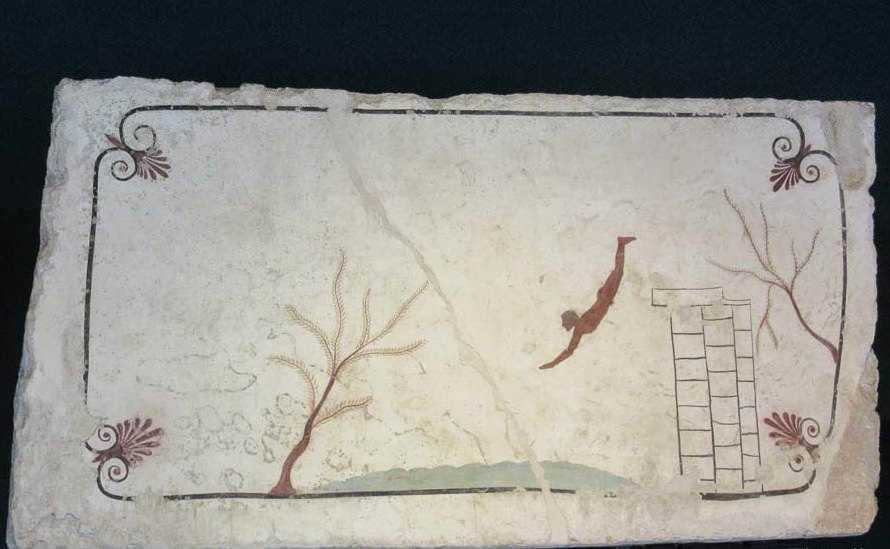 Caduta di un uomo da una parete di un palazzo, con alberi e scritte antiche sullo sfondo, su un muro di pietra antica, all'aperto, scenario storico e urbano.