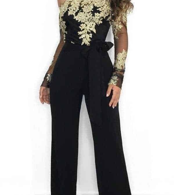Elegante donna in tuta nera con ricami dorati e dettagli in pizzo, look sofisticato per occasioni speciali.