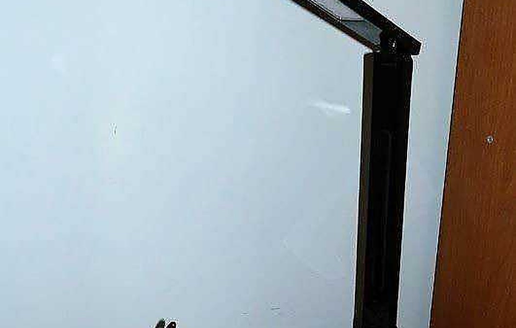 Lampada da tavolo LED nera, moderna e regolabile per illuminazione ottimale, posizionata su scrivania o tavolo. Ideale per studi, uffici e ambienti di lavoro per una luce direzionale e versatile.