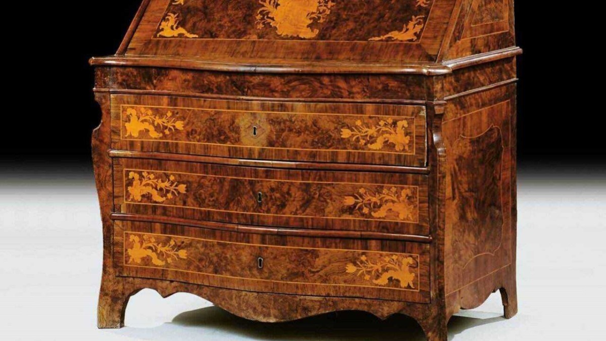 Antico scrittoio in legno pregiato con intricati intarsi artistici e dettagli decorativi, esempio di abilità artigianale e stile storico. Perfetto complemento d'arredo raffinato per ambienti classici.