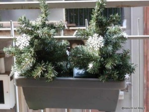 Addobbo natalizio con pino artificiale decorato con fiocchi di neve in una fioriera sul balcone. Perfetto per decorare la casa durante le festività natalizie. Idee di decorazioni di Natale fai-da-te.