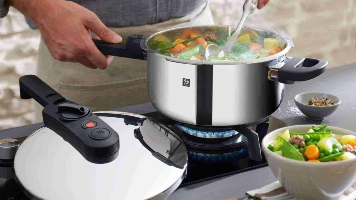 Pentole a pressione moderne in cucina, preparazione di minestre e zuppe con verdure fresche, tecnologia avanzata per cucinare in modo rapido e sicuro.