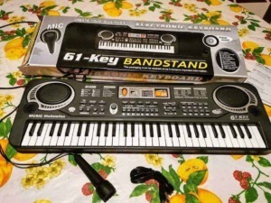 61-key keyboard electronic music instrument with microphone, music workstation and stand, suitable for beginners, digital display, and multiple control buttons for music creation.
