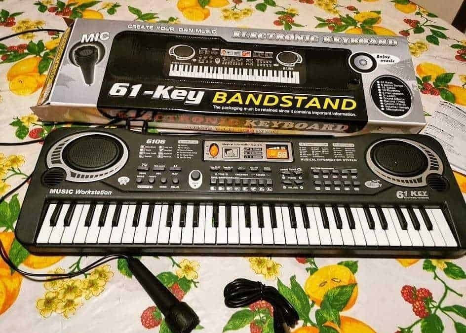 61-key keyboard electronic music instrument with microphone, music workstation and stand, suitable for beginners, digital display, and multiple control buttons for music creation.