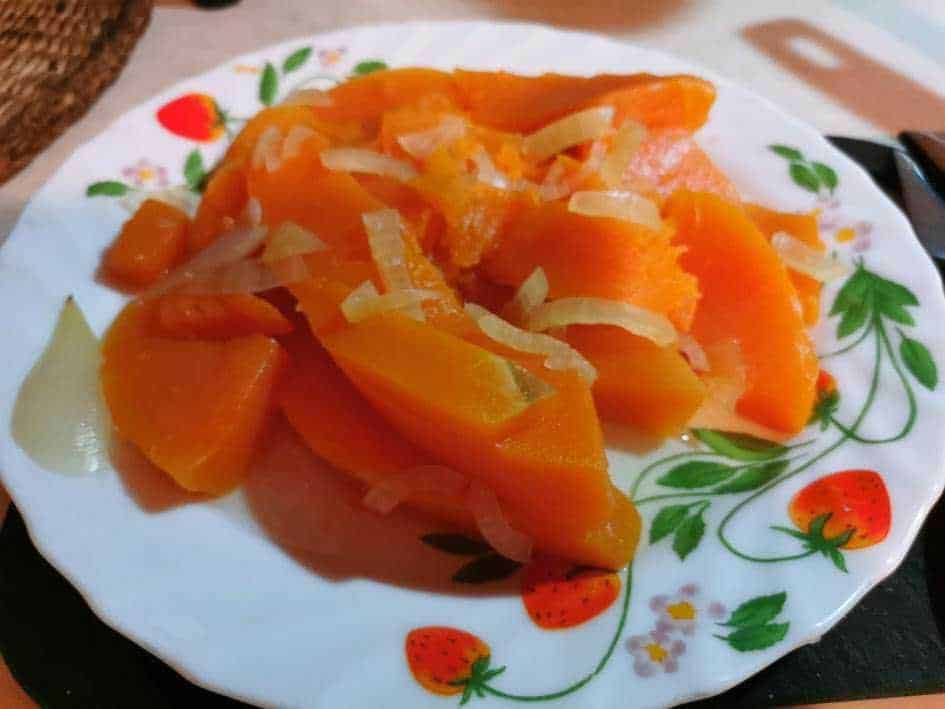 Tempi di cottura pentola a pressione: Tempi di cottura in pentola a pressione: Pomodori freschi con cipolla affettata su piatto decorato, in stile casalingo, ottimi come antipasto o contorno, perfetti per una cucina italiana genuina e tradizionale.