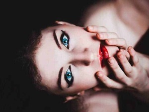 Belle donna con trucco occhi marcato, labbra rosse e trucco sofisticato in primo piano, rappresentando bellezza e moda.