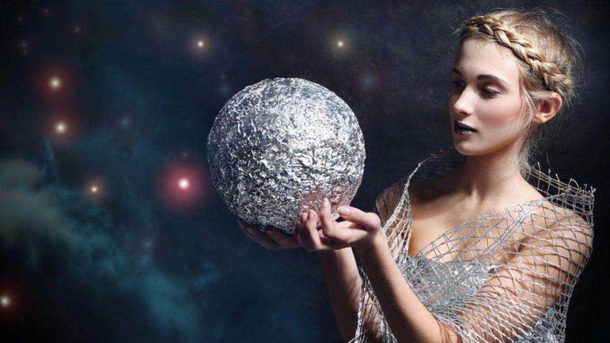 Sfera luminosa simile a un pianeta o luna in mano a una donna con capigliatura elegante in ambientazione spaziale digitale.