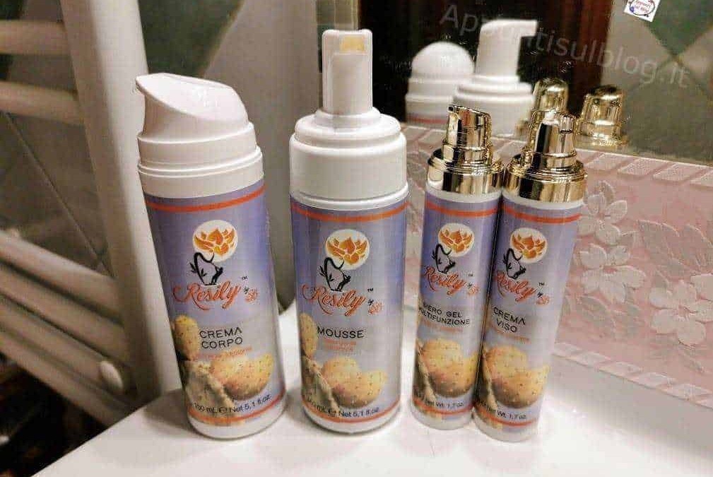 Creme corpo e viso Resdly in confezioni spray, prodotti cosmetici idratanti e nutrienti per la cura della pelle, visibili sul banco in bagno.