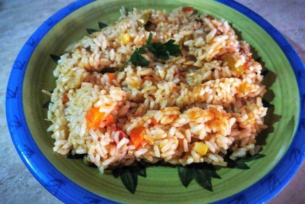 Risotto alle verdure in ciotola colorata con cipolla, carote e mais, piatto caldo e gustoso.