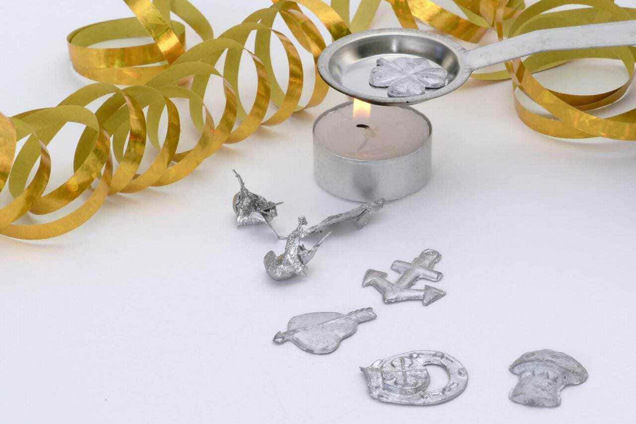 Decorazioni di Capodanno con candele, teddy bear, orsetti di cioccolato e festoni dorati per un’immagine di celebrazione e festa. Perfetto per articoli blog su eventi e feste di fine anno.