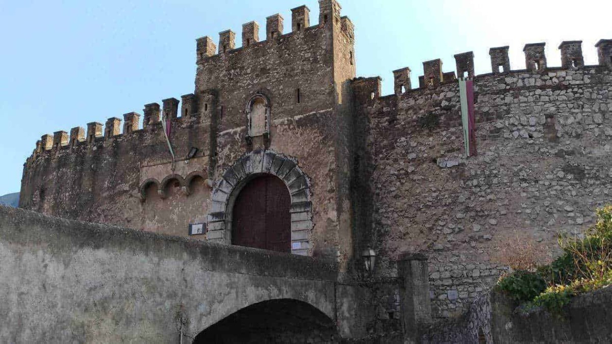 Castello medievale in pietra con torre e mura difensive, ingresso in stile storico, situato in un paesaggio italiano, perfetto esempio di architettura antica e patrimonio culturale.