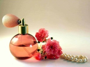 Fragranza floreale con bouquet di fiori rosa, profumo femminile, bottiglia di profumo elegante, accessori moda come perle e fiori, atmosfera di raffinatezza e stile.