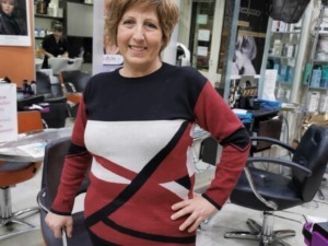 Capelli corti e sorriso in un salone di parrucchieri, ambiente moderno e professionale, pronta per un taglio o un trattamento di bellezza.