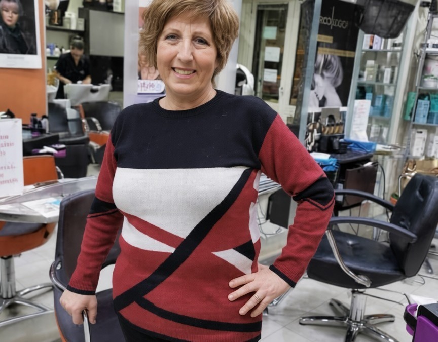 Capelli corti e sorriso in un salone di parrucchieri, ambiente moderno e professionale, pronta per un taglio o un trattamento di bellezza.