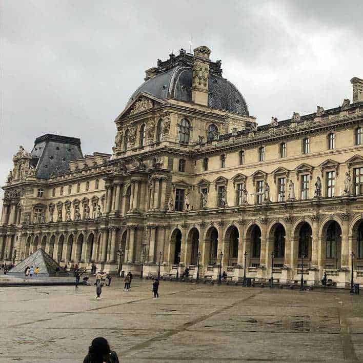 Amanti dell'Arte visiva, scopri 12 città culturali 8 Architettura storica e facciata del Museo del Louvre a Parigi, esempio di arte e cultura francese.