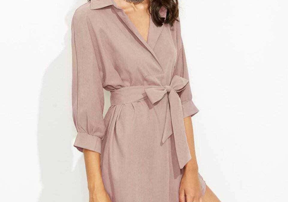 Elegante donna in vestito rosa con cintura a fiocco, cappello nero e collana alla moda, stile casual chic perfetto per look primaverili ed estivi.