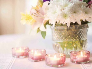 Fiori decorativi in vaso con candele rosa accese, ambiente elegante e romantico.
