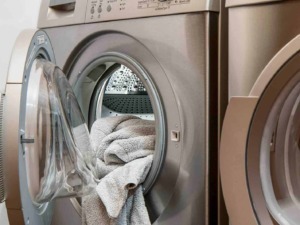 Lavatrice moderna aperta con asciugamani in cotone morbido e spugnosos, dettaglio di elettrodomestici in casa, tecnologia per bucato, cura dei tessuti, lavaggio e igiene domestica.