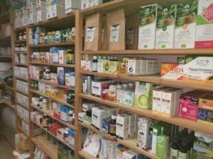 Integratori naturali e prodotti biologici su scaffali di farmacia o negozio di alimenti health food store.