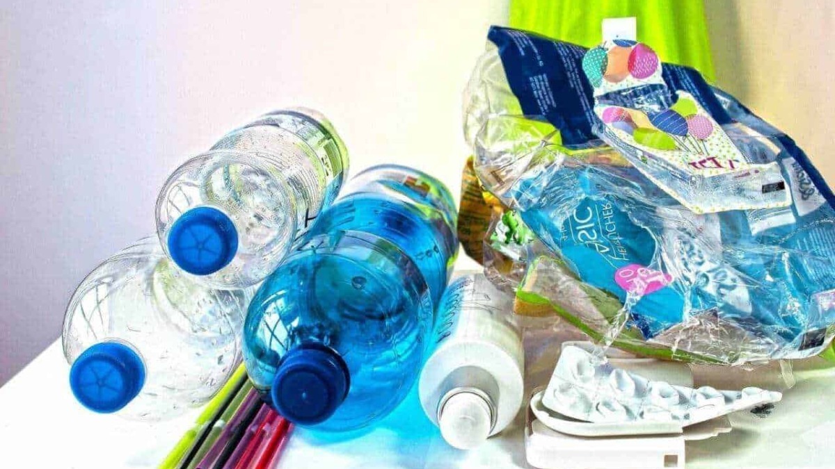Bottiglie di plastica con acqua e cannucce colorate per riciclo e rifiuti.