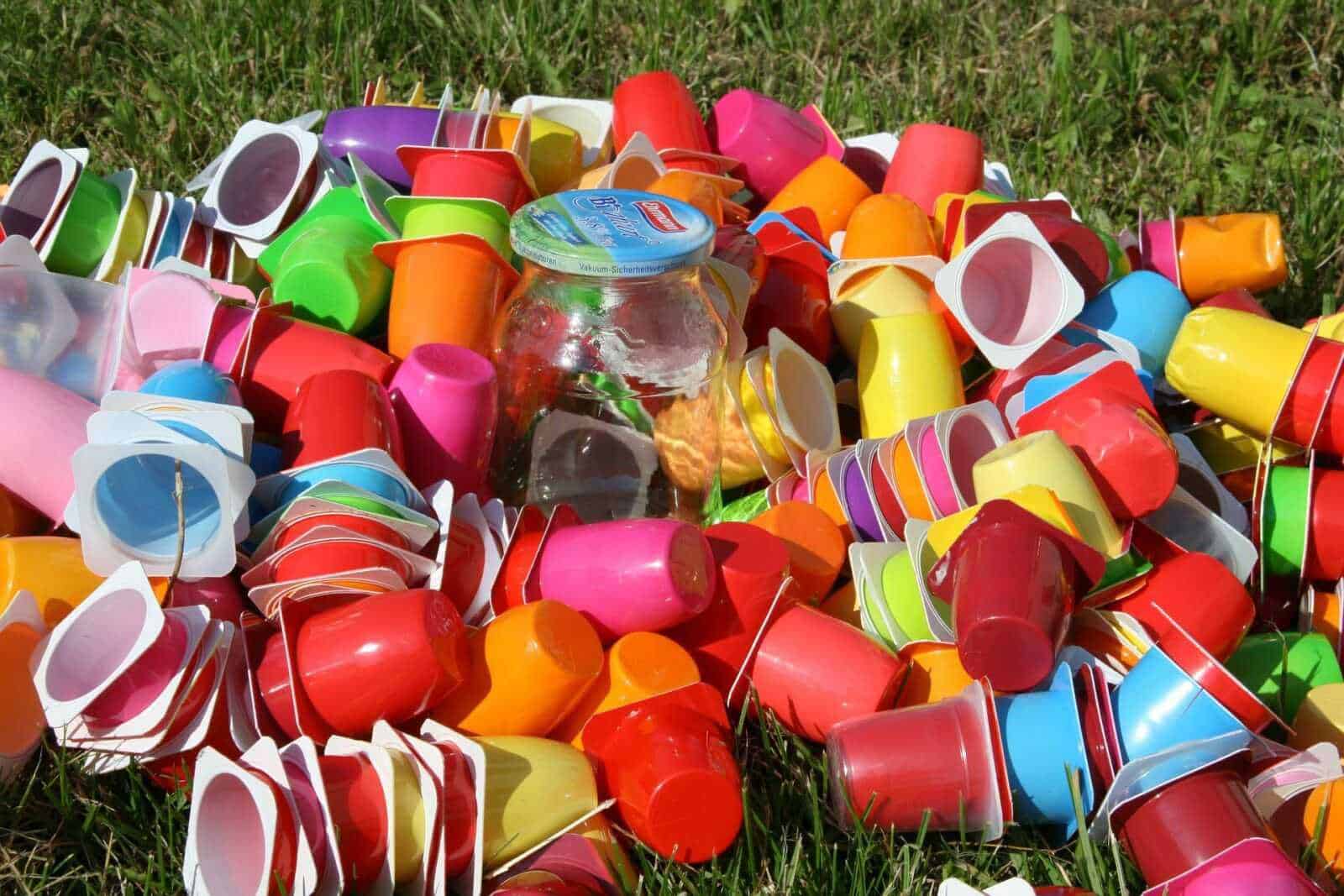 Ridurre il consumo di plastica, 3 semplici consigli 2 Colorati bicchieri di plastica abbandonati su erba, simbolo di spreco e rifiuti ambientali.