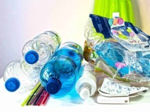Bottiglie di plastica con acqua e cannucce colorate per riciclo e rifiuti.