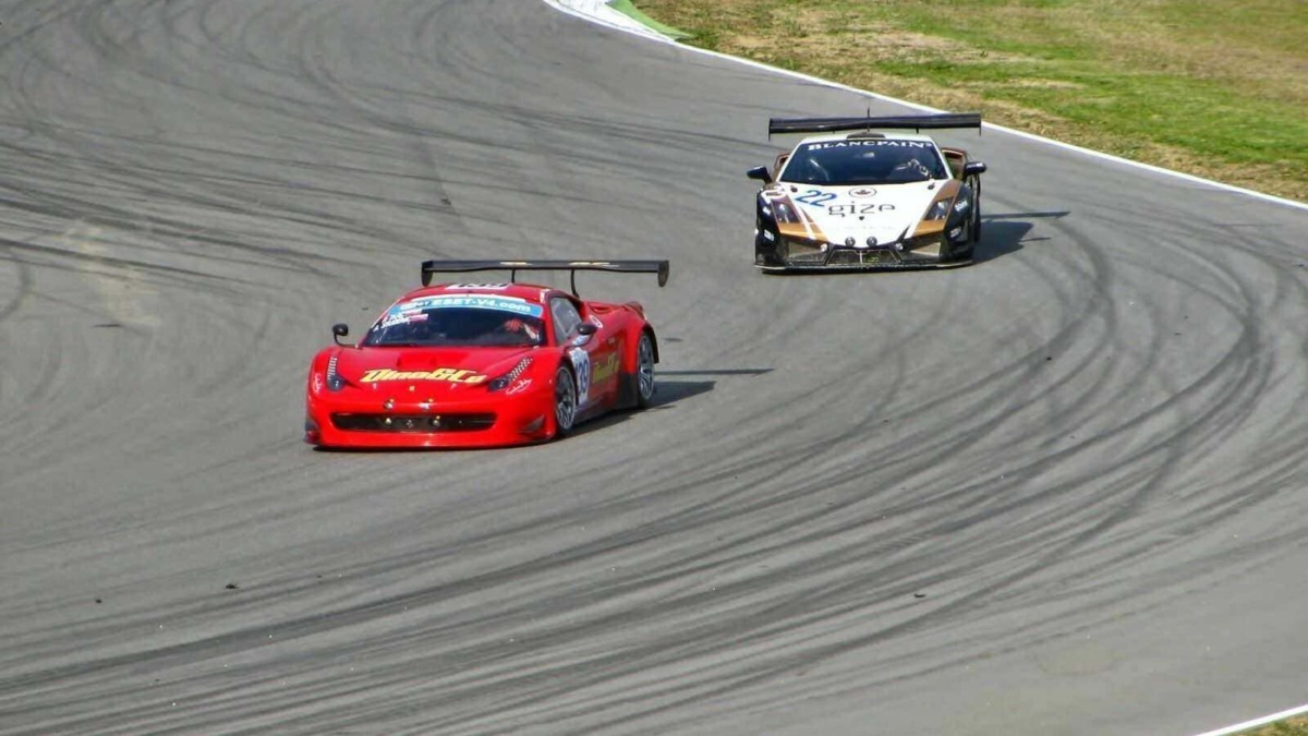Ferrari da corsa e Lamborghini in gara su circuito, automobili sportivi racing a alta velocità durante una gara di endurance.