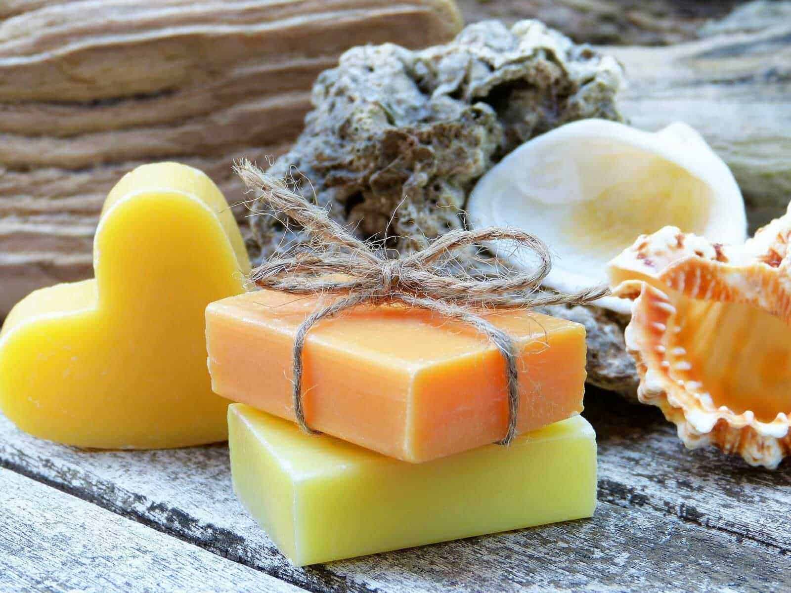 Sapone naturale fatto a mano con profumi e colori delicati, perfetto per la cura della pelle e il benessere, presentato su superficie di legno rustico come decorazione naturale.