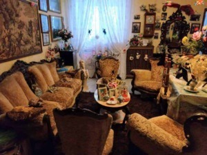 Antico salotto con mobili in stile vintage, divani imbottiti e decorazioni floreali, atmosfera accogliente e ricca di dettagli decorativi, ideale per appunti sul blog e contenuti di stile di vita.