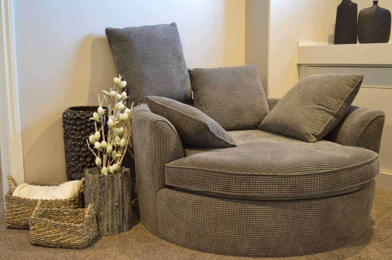Sedia a cuore in tessuto beige con cuscini coordinati in stile moderno e decorazioni in ambiente domestico eleganti e accoglienti.