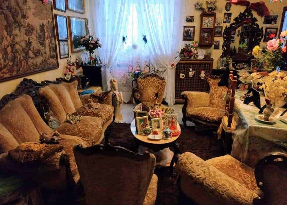 Antico salotto con mobili in stile vintage, divani imbottiti e decorazioni floreali, atmosfera accogliente e ricca di dettagli decorativi, ideale per appunti sul blog e contenuti di stile di vita.