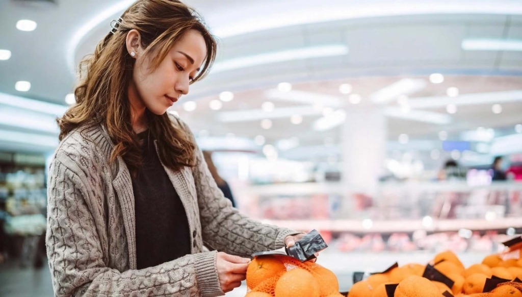 Donna al supermercato mentre fa la spesa