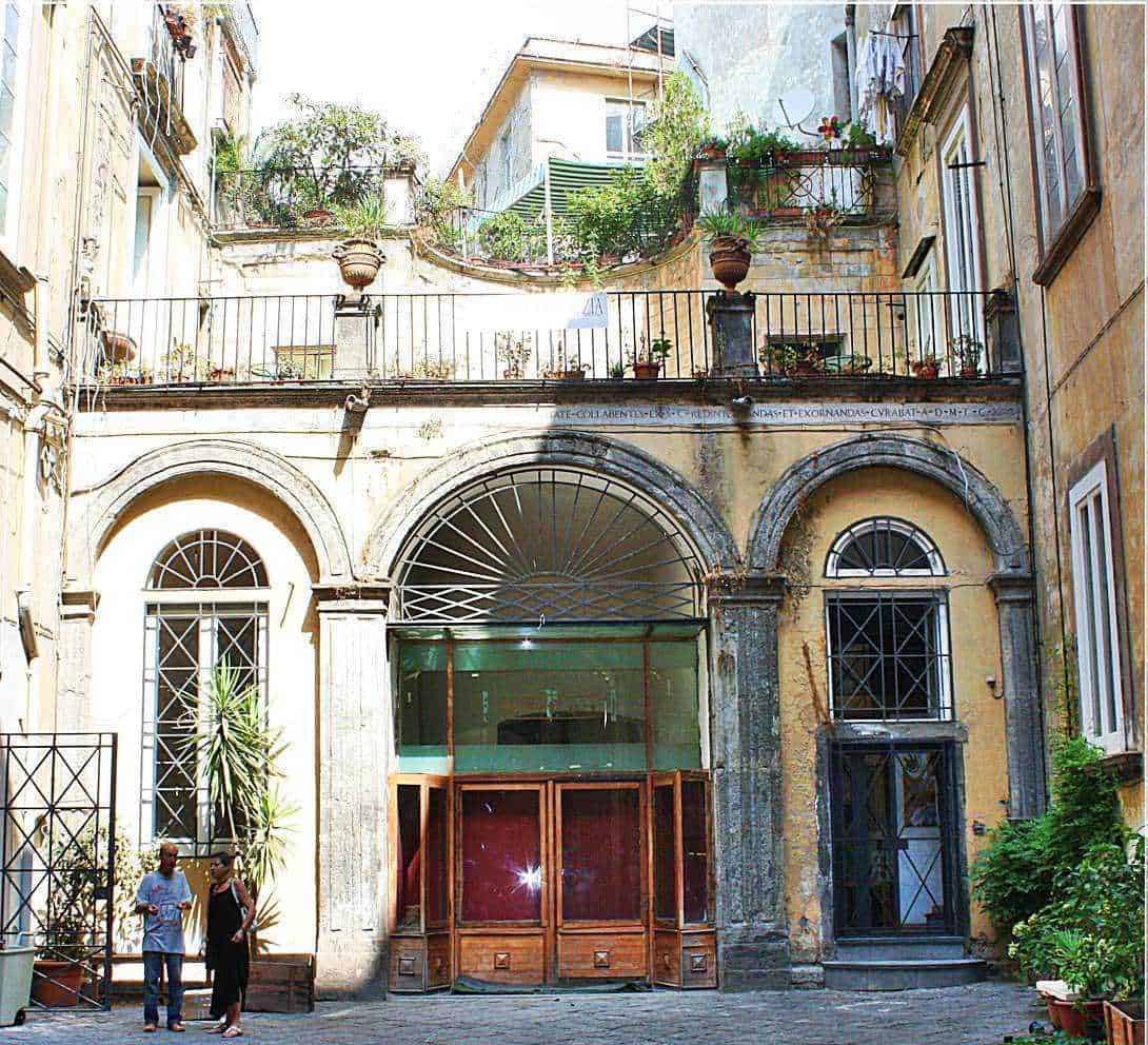 Benvenuti nel cuore di una storica strada cittadina con facciate colorate e balconi fioriti, perfetta per appunti sul blog di viaggi e cultura italiana. Scene di vita quotidiana e charme medievale in un'immagine autentica.