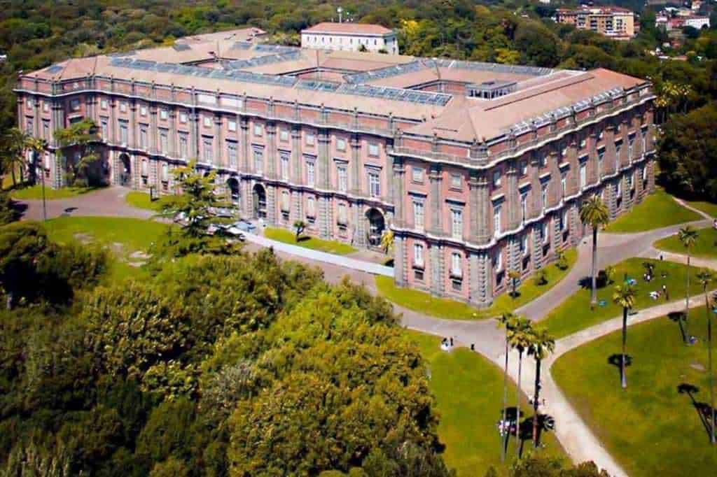 Palazzo storico in stile neoclassico circondato da parco verde con sentieri e alberi tropicali, vista aerea edificio culturale e università a Roma, Italia.