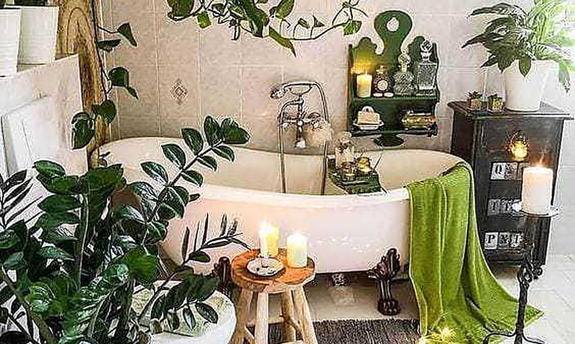 Fioritura di piante verdi in bagno con vasca da bagno vintage, illuminata da candele e luci soffuse, creando un'atmosfera rilassante e naturale.