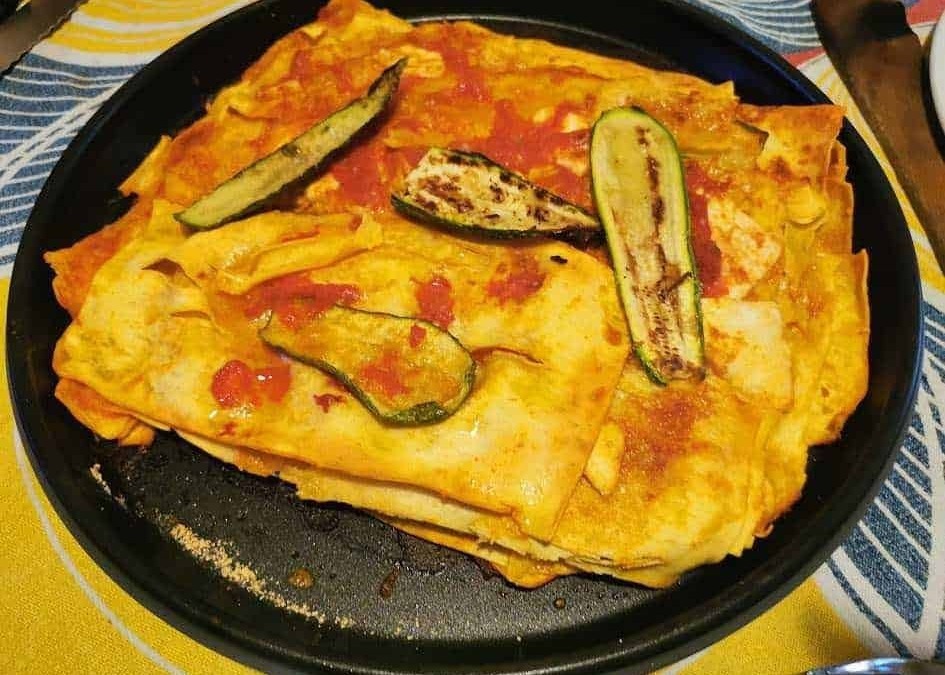 Pomodoro e zucchine su farfalle e lasagna, piatto di pasta italiana, cucina mediterranea, cibo autentico, ricetta italiana, pasto gustoso, piatto di pasta caldo.