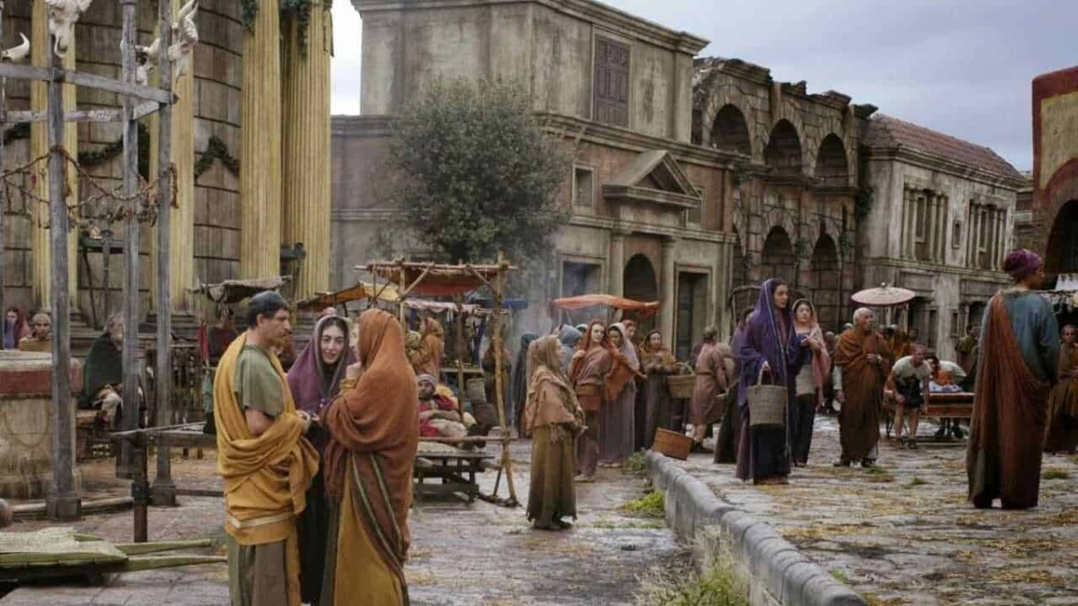 Antico mercato romano ricostruito con attori in costumi dell'epoca, scena storica e ambientazione archeologica, rappresentazione di vita quotidiana nell'antica Roma.