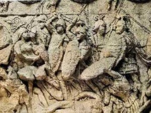Dettaglio di stucchi e rilievi antichi su una parete di monumento storico romano.