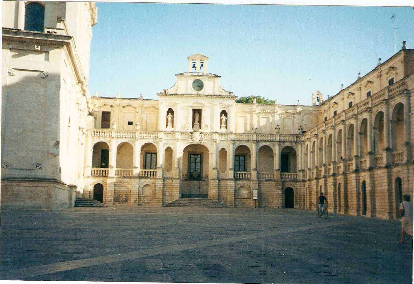 Viaggio in Puglia con Voyage Privé: 7 luoghi più belli da visitare 7 Palazzo storico con archi e statue, centro urbano, architettura barocca, edificio storico in pietra, piazza antistante, patrimonio culturale italiano, atmosfera mediterranea, viaggio in Italia, luogo di interesse storico.