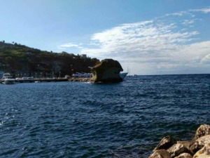 Scogliera e mare a Capri con yacht e barche, paesaggio marino italiano.