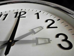 Orologio analogico in close-up, focus sul quadrante con onde le lancette segnano quasi le 12:30, evidenziando il design minimalista e l'eleganza dell'orologio.