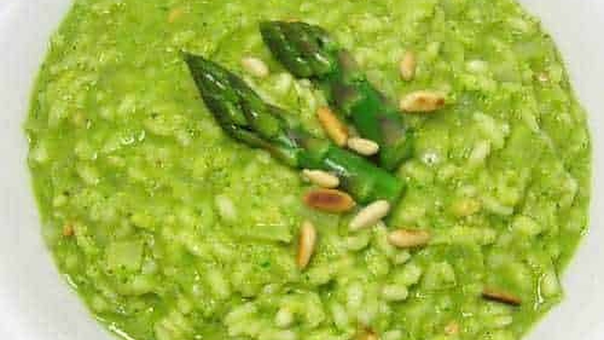 Verdure di zucchine tritate e soffritte, guarnite con punte di asparagi e semi di girasole, in un piatto colorato e appetitoso. Una ricetta leggera e salutare, ideale per una dieta equilibrata.