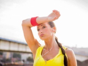 Sudore donna in allenamento durante corsa all'aperto con cuffie, sport e fitness.