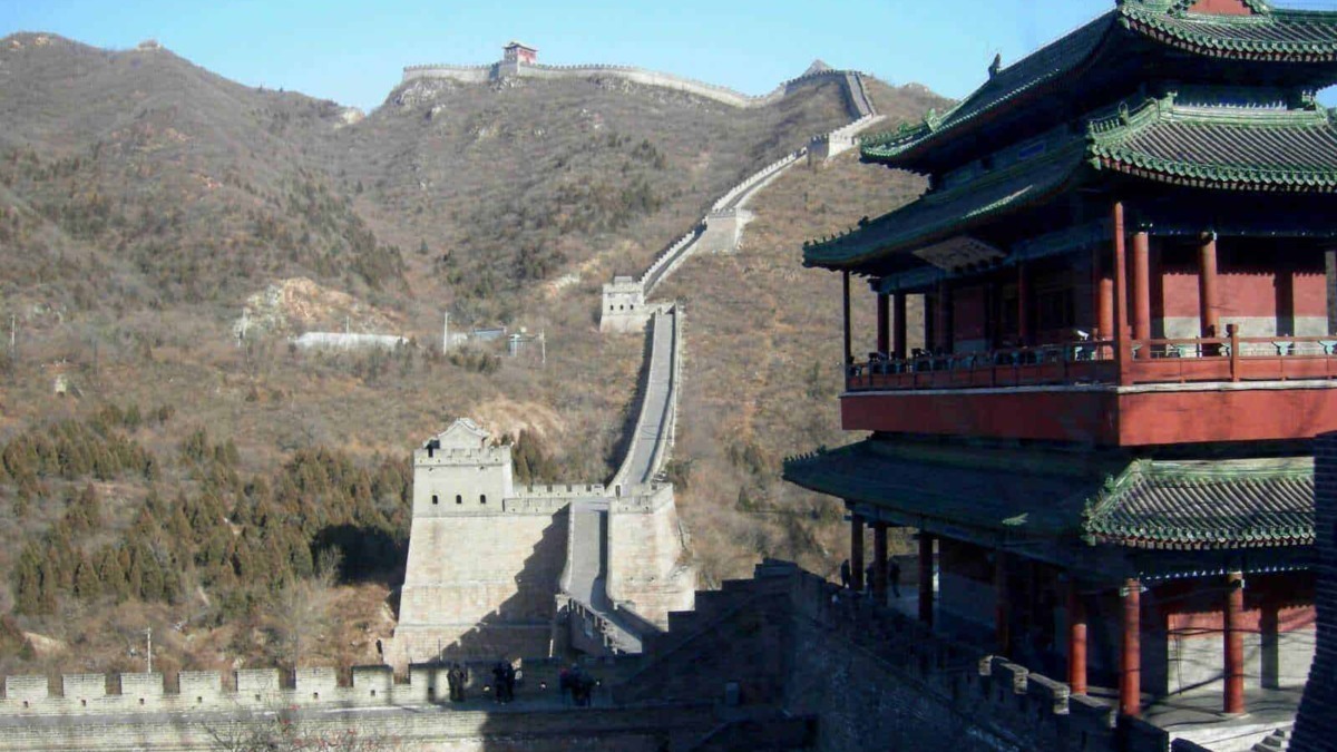 Faro di Badaling sulla Grande Muraglia cinese con paesaggio montano e cielo blu, struttura tradizionale cinese e vista panoramica delle antiche mura.