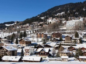 Neve su case e appartamenti di montagna nel paesaggio alpino in inverno.