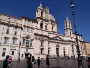 Maestosa chiesa barocca nel cuore di Roma con dettagli architettonici intricati e una grande cupola, visitata da turisti e appassionati di arte religiosa.