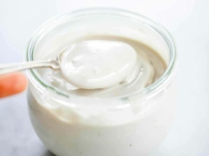 Crema di yogurt bianco in barattolo con cucchiaio, alimento salutare e gustoso, ideale per colazioni e snack nutrienti, perfetta per ricette di dolci e dessert salutari.